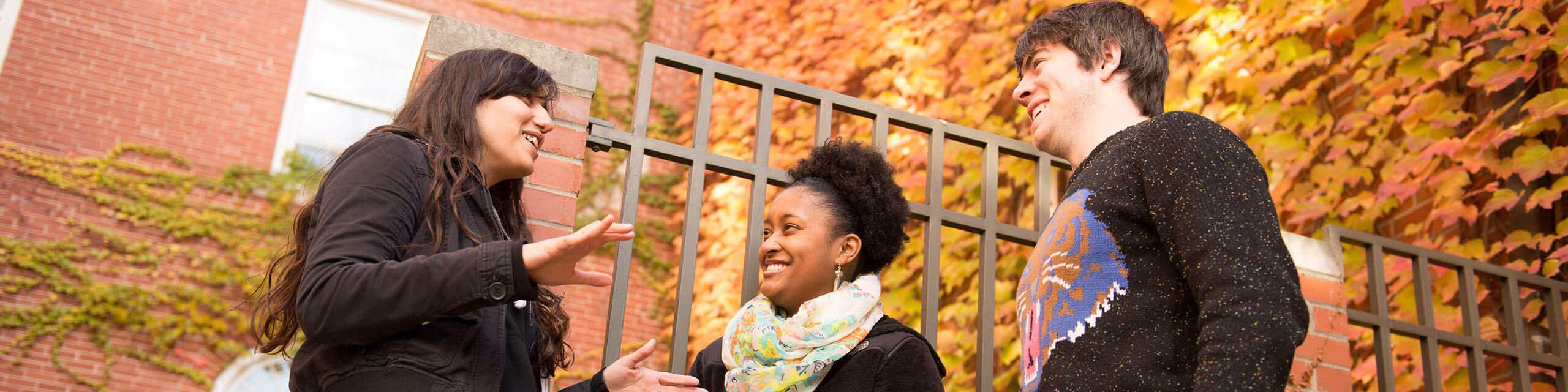 Three students together outside of a building