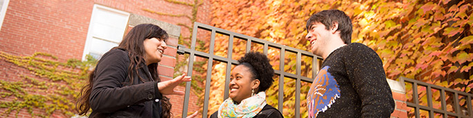 Three students together outside of a building